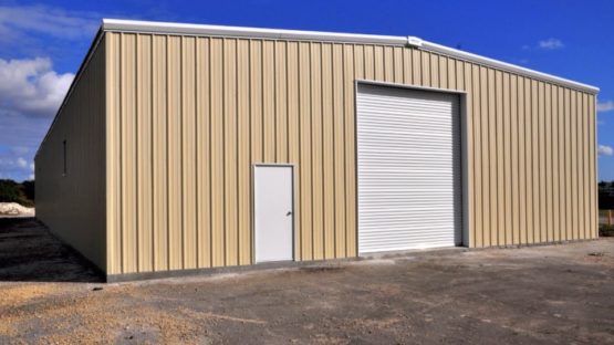 Tan commercial steel warehouse with one rollup door and one 3070 walk door.